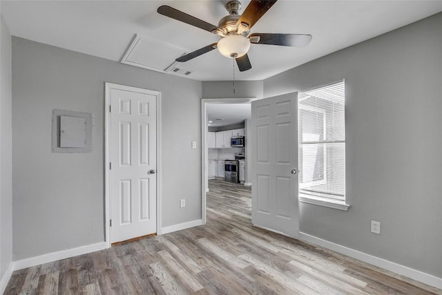 interior space with ceiling fan, electric panel, and light hardwood / wood-style floors