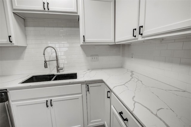 kitchen with sink, white cabinets, and light stone counters