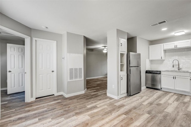 kitchen featuring white cabinetry, sink, light hardwood / wood-style flooring, and stainless steel appliances