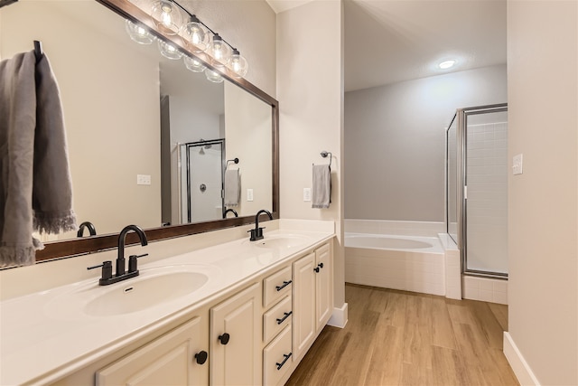 bathroom featuring vanity, independent shower and bath, and hardwood / wood-style floors