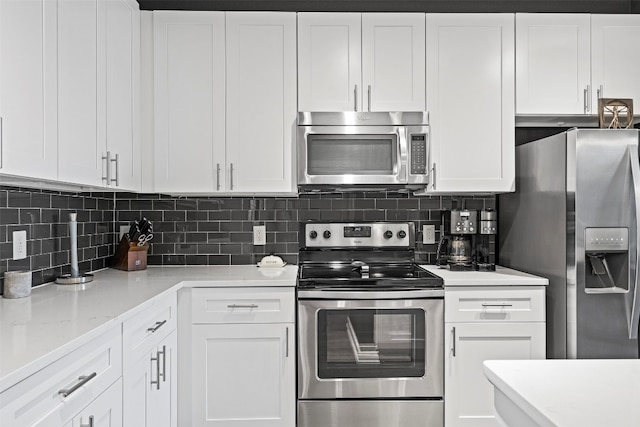 kitchen featuring white cabinets, backsplash, light stone counters, and appliances with stainless steel finishes