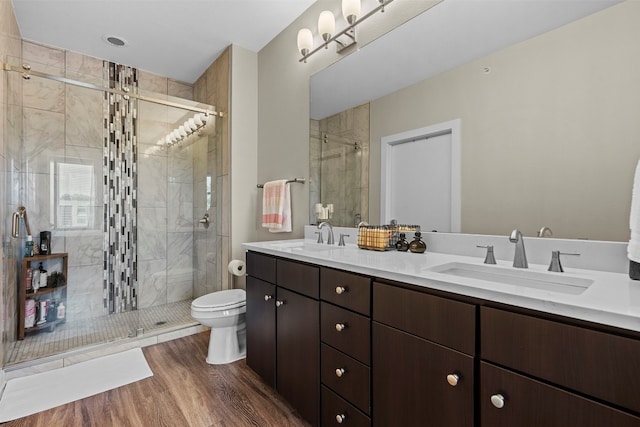 bathroom featuring walk in shower, wood-type flooring, toilet, and double sink vanity