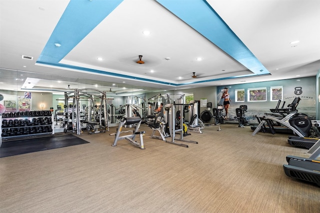 gym with light colored carpet and a tray ceiling