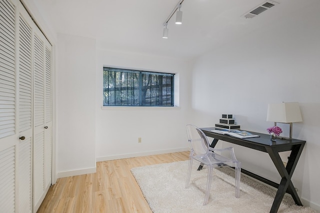 office space with track lighting and light hardwood / wood-style flooring