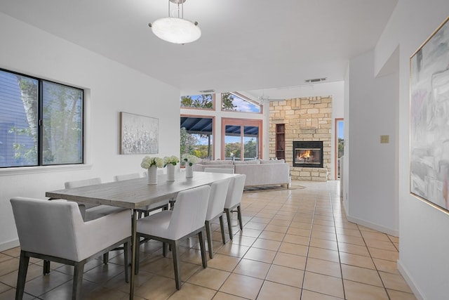 dining area featuring a fireplace and light tile patterned floors