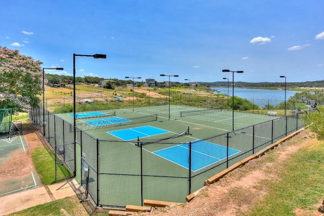 view of tennis court with a water view