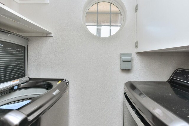 laundry room featuring cabinets and washer / clothes dryer