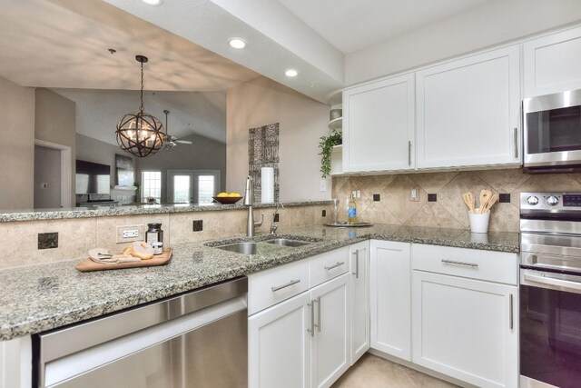 kitchen with white cabinetry, appliances with stainless steel finishes, and vaulted ceiling