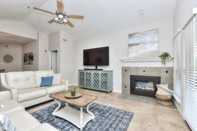 living room with ceiling fan, a fireplace, a wealth of natural light, and vaulted ceiling