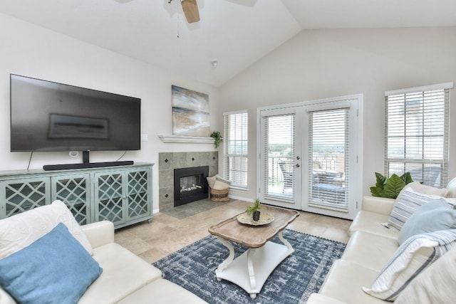 tiled living room featuring ceiling fan, a healthy amount of sunlight, french doors, and a tiled fireplace