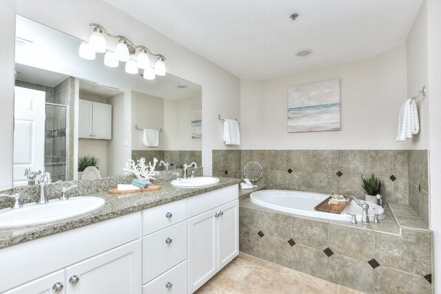 bathroom featuring tile patterned flooring, vanity, and plus walk in shower