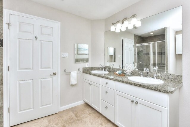 bathroom featuring tile patterned floors, vanity, and a shower with shower door