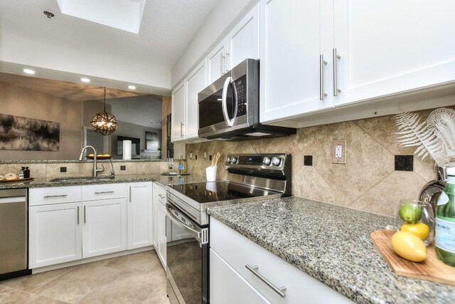 kitchen with sink, decorative light fixtures, white cabinetry, stainless steel appliances, and a chandelier