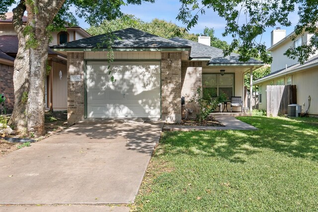 view of front of home with a garage, a front lawn, and cooling unit