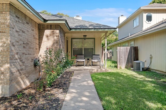 view of exterior entry featuring central AC and a lawn