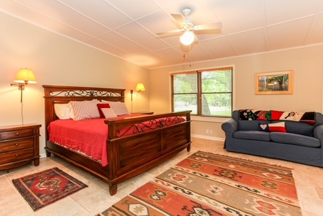 tiled bedroom featuring ceiling fan