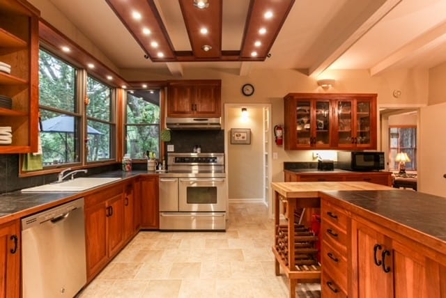 kitchen featuring decorative backsplash, dishwasher, stove, and light tile patterned floors