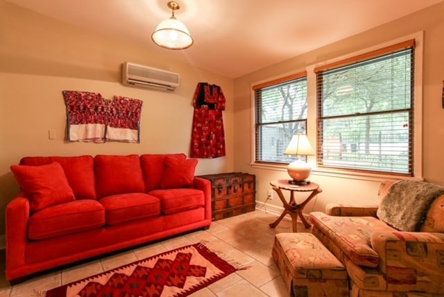 tiled living room featuring a wall mounted air conditioner