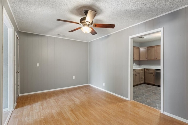 spare room with ceiling fan, a textured ceiling, hardwood / wood-style flooring, and ornamental molding