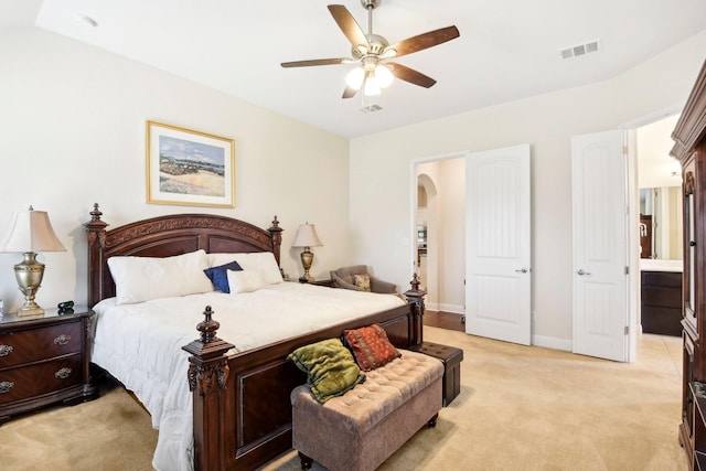 carpeted bedroom featuring ceiling fan and ensuite bath