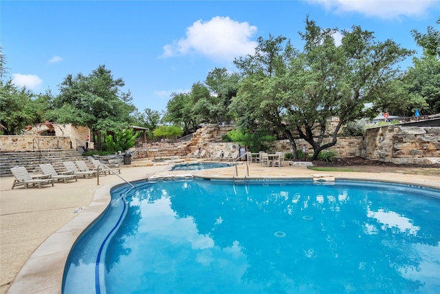 view of pool with a hot tub and a patio area