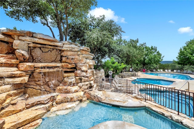 view of pool with a hot tub and a patio