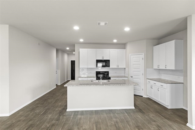 kitchen featuring a kitchen island with sink, tasteful backsplash, black appliances, and white cabinets