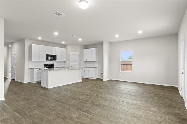 kitchen with an island with sink, dark wood-type flooring, white cabinets, and black appliances