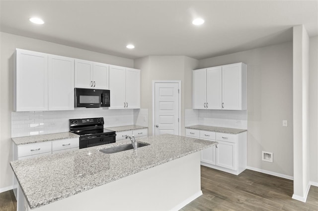 kitchen featuring white cabinetry, sink, a center island with sink, and black appliances