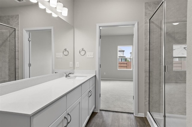 bathroom featuring wood-type flooring, an enclosed shower, and vanity