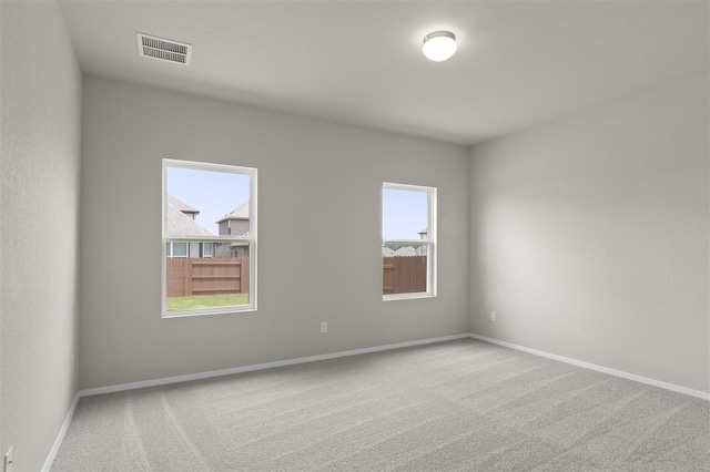 unfurnished room featuring carpet and a wealth of natural light