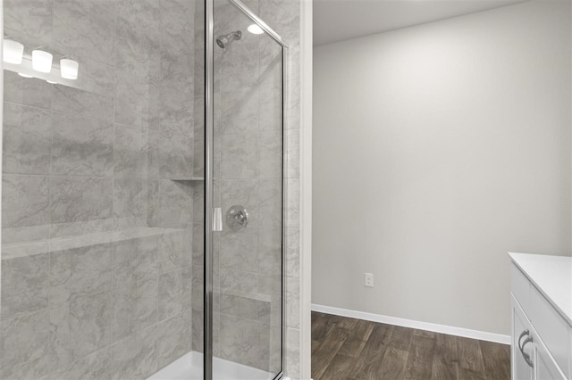 bathroom featuring walk in shower, vanity, and wood-type flooring