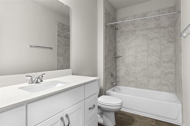 full bathroom with vanity, toilet, tiled shower / bath combo, and hardwood / wood-style floors