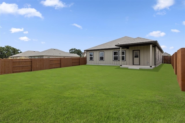 rear view of house featuring a yard