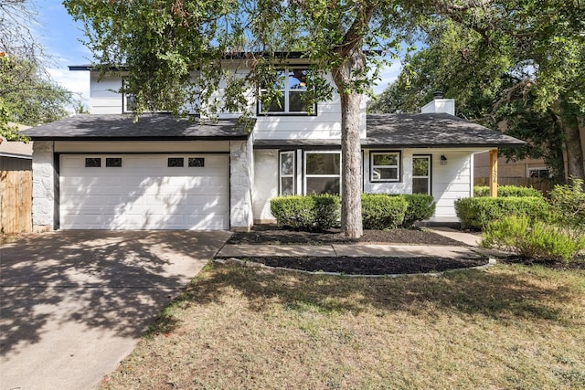 view of front of home featuring concrete driveway, a front lawn, and an attached garage