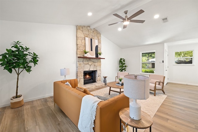 living room featuring ceiling fan, vaulted ceiling with beams, light hardwood / wood-style floors, and a fireplace