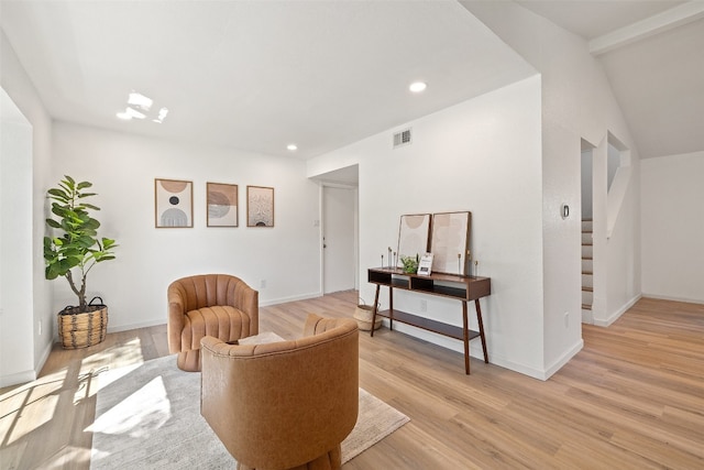 sitting room with light wood-type flooring and lofted ceiling