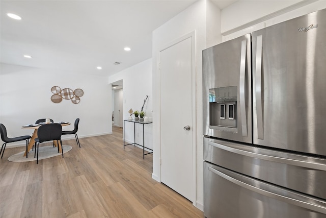 kitchen with light wood-type flooring and stainless steel refrigerator with ice dispenser