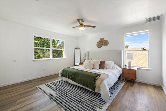 bedroom featuring wood-type flooring, multiple windows, and ceiling fan