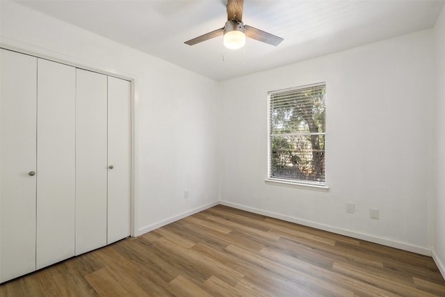 unfurnished bedroom with ceiling fan, a closet, and light hardwood / wood-style floors