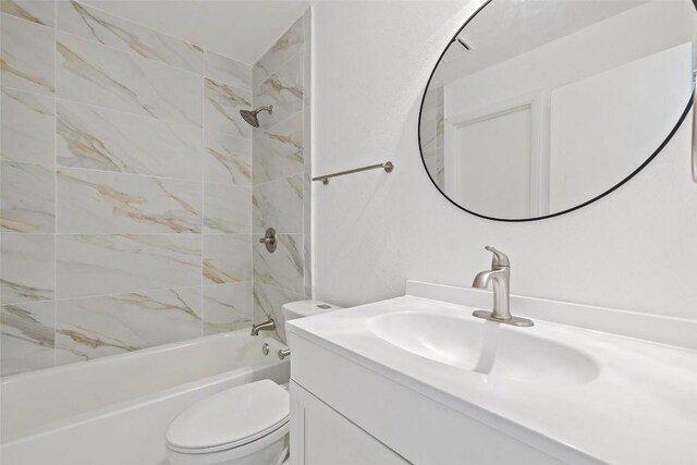 full bathroom featuring tiled shower / bath combo, vanity, and toilet