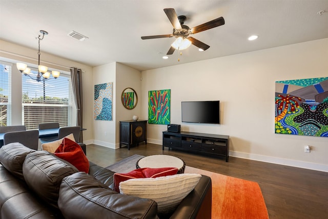 living room with dark hardwood / wood-style floors and ceiling fan with notable chandelier