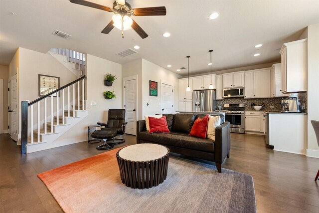 living room featuring dark hardwood / wood-style flooring and ceiling fan