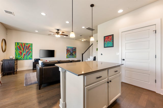 kitchen featuring pendant lighting, white cabinetry, dark hardwood / wood-style flooring, a center island, and ceiling fan