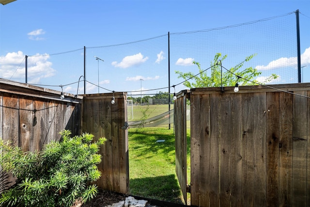 view of gate with a lawn