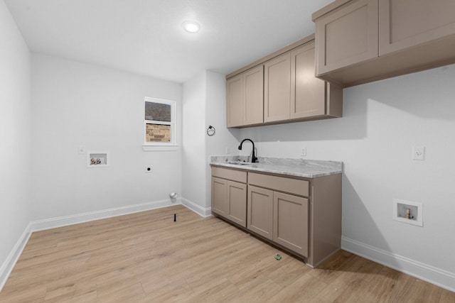 washroom featuring sink, hookup for an electric dryer, washer hookup, and light hardwood / wood-style floors