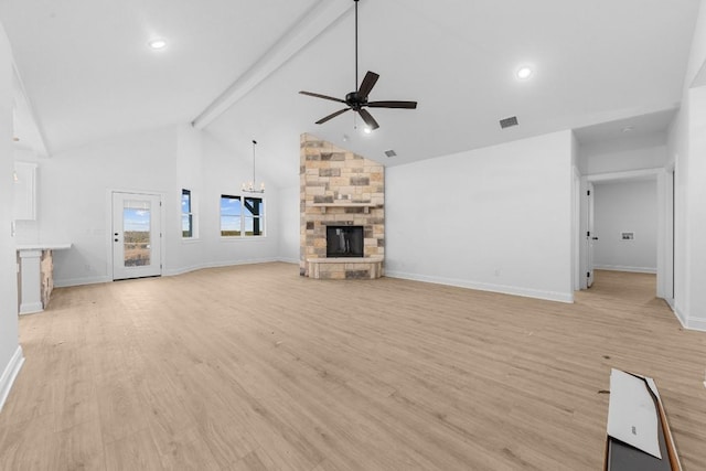 unfurnished living room featuring a stone fireplace, high vaulted ceiling, ceiling fan with notable chandelier, beam ceiling, and light hardwood / wood-style floors