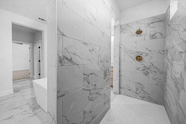 bathroom with tiled shower and tile patterned flooring