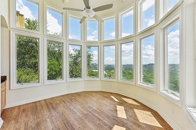 unfurnished sunroom featuring ceiling fan