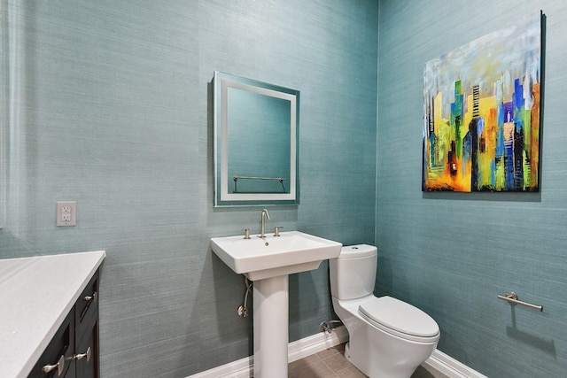 bathroom with toilet, tile patterned floors, and sink